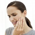 Young Woman Holding the Side of Her Face in Pain